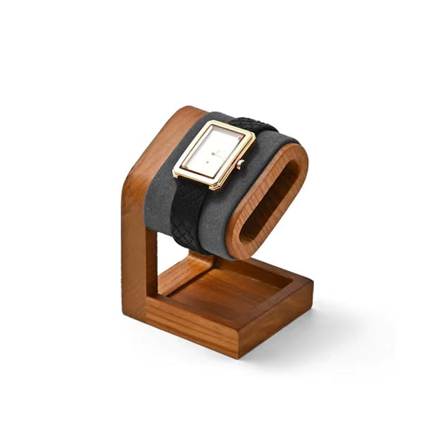 Wooden watch stand with a black strap watch on a white background